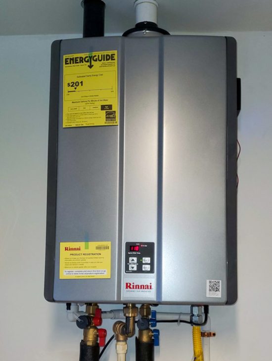 A residential tankless water heater installed neatly on the wall, complete with energy efficiency details and modern plumbing connectivity.