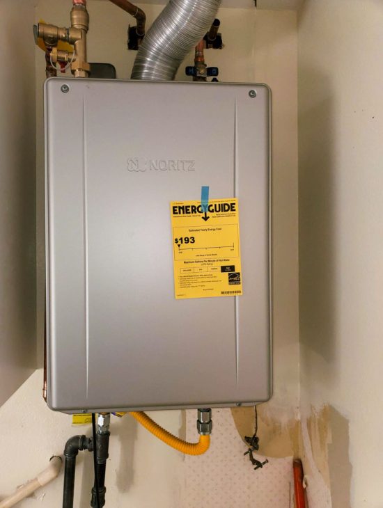 Wall-mounted energy-efficient gas heater with an attached energy guide sticker, emphasizing sustainable home heating solutions.