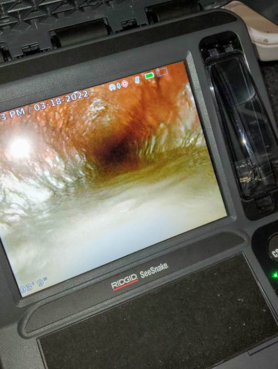 Close-up of a RIDGID SeeSnake monitor displaying the interior of a pipe, used for detailed plumbing inspections.