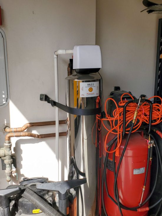 Water filtration system and storage equipment in a utility area, illustrating a clean and organized installation.