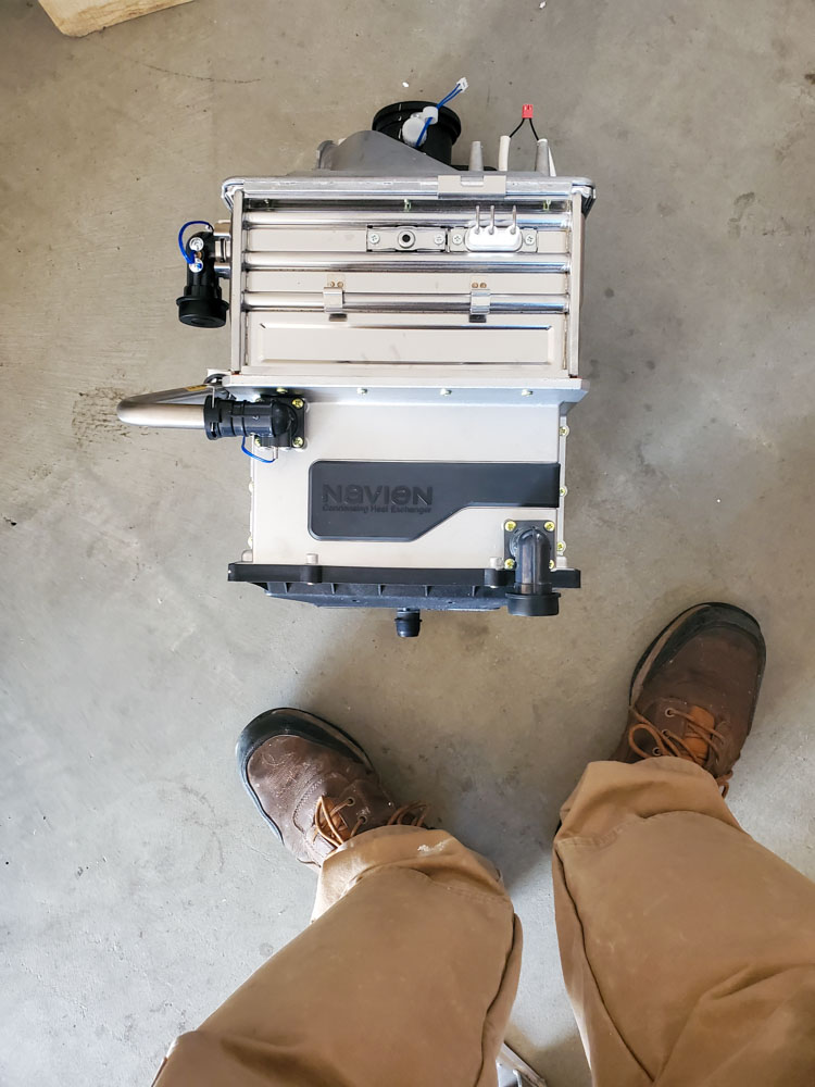 Overhead view of a Navien boiler installation, showing the top of the unit and connected plumbing lines.