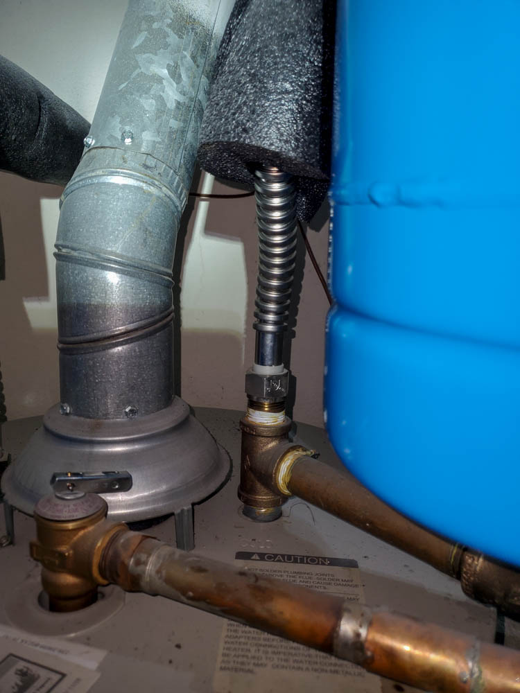 Close-up of an industrial water filtration system with connected hoses and piping in a utility area.